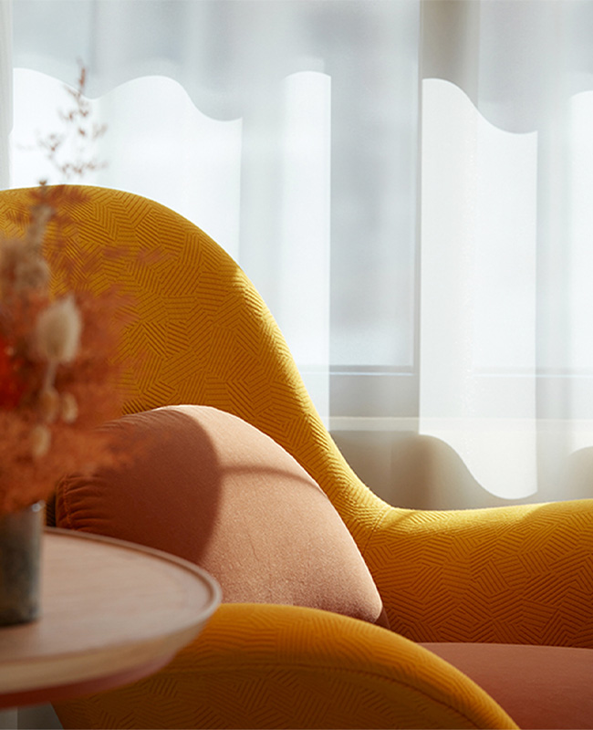 Yellow armchair and small coffee table next to a window