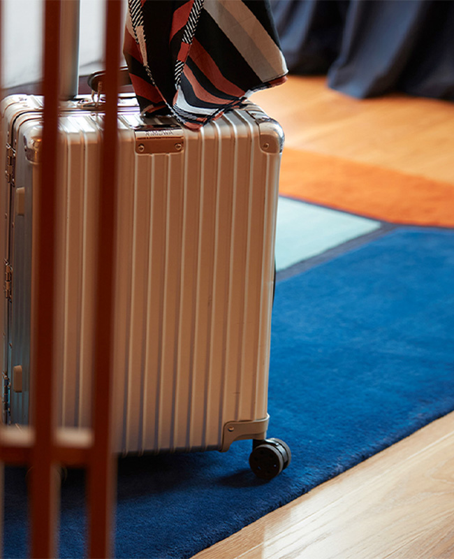 Silver Suitcase behind slatted wooden divider