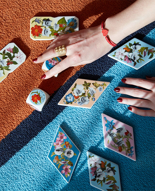 A hand reaching for marble tiles scattered on the floor