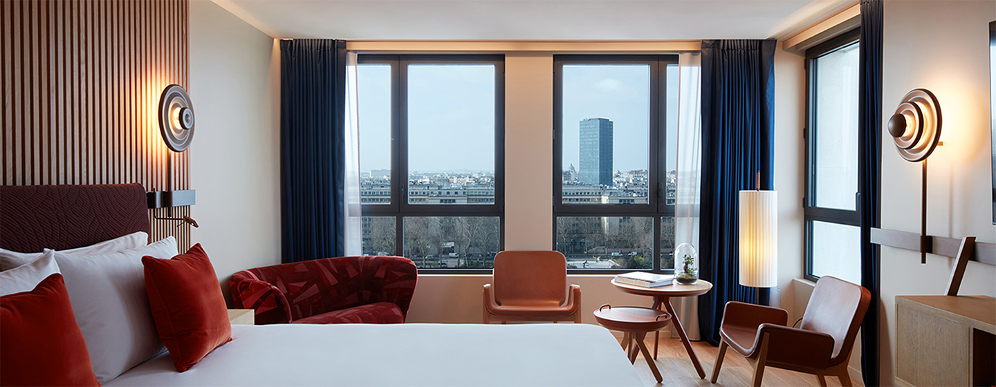 Full view of Bedroom with King bed, seating area and view of Paris skyline