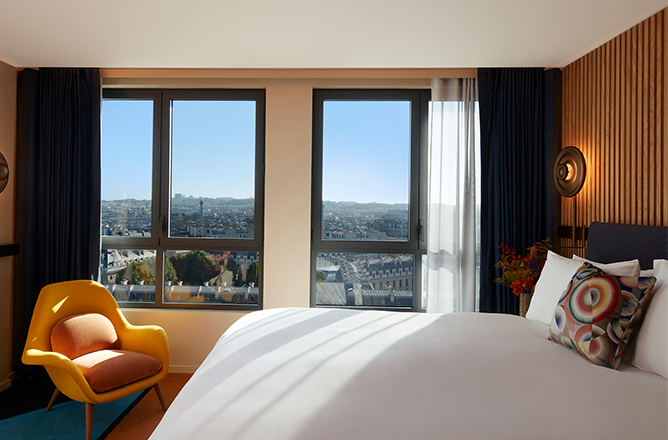 http://King%20bed%20and%20yellow%20armchair%20with%20beautiful%20skyline%20view%20of%20Paris