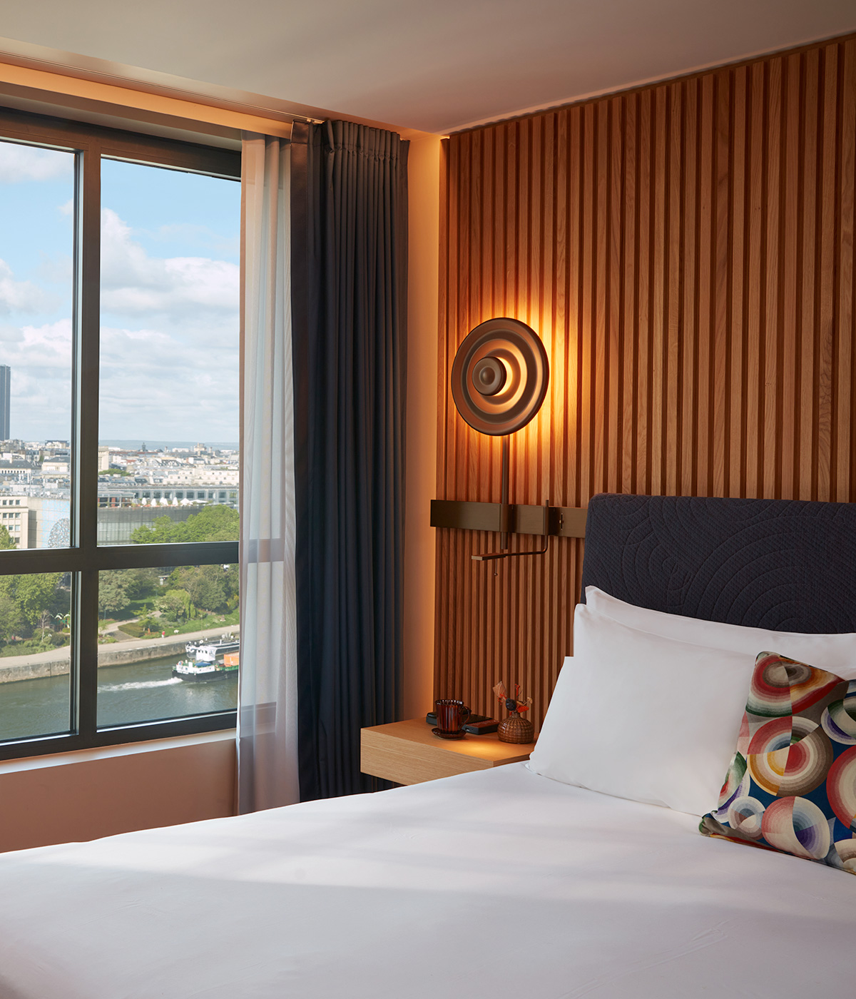 Interior of the iconic Paris skyline room including sunny city view and soft pillows.
