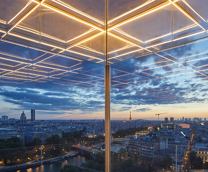 15th Floor bay windows over looking Paris at sunset with the illutminated floor reflected in the glass