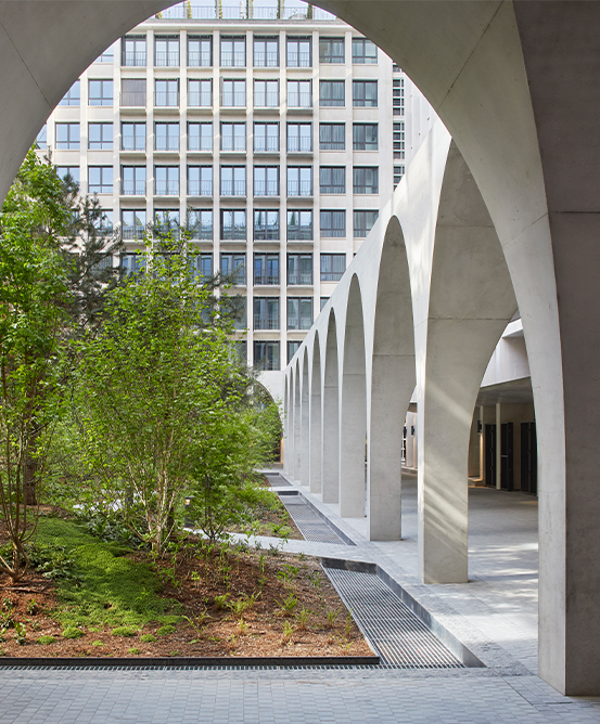 Exterior courtyard filled with trees, surrounded by arched walk way