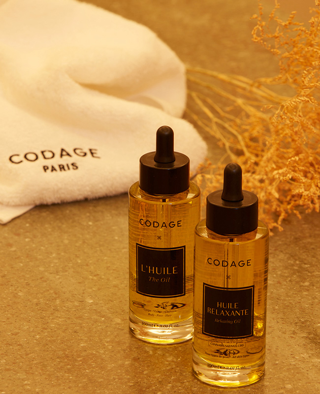 Two CODAGE treatment oils next to a white CODAGE Paris towel 