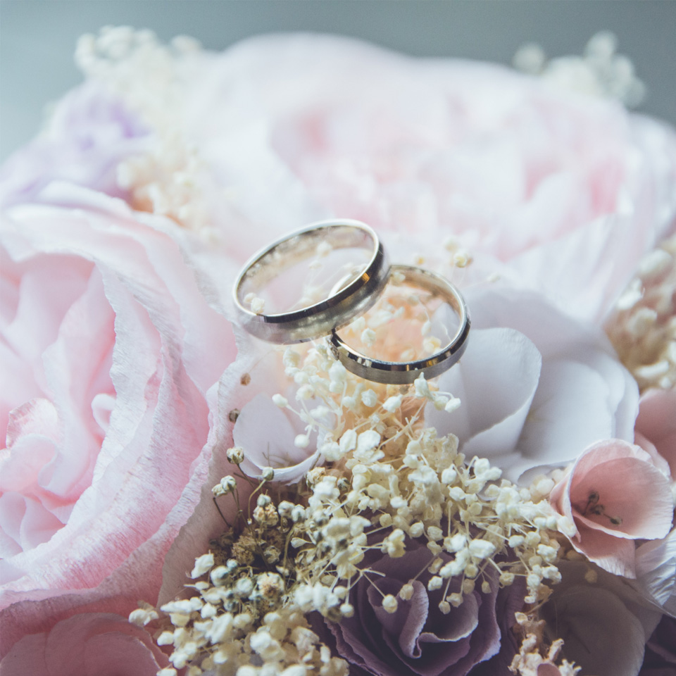 A bouquet of beautiful flowers with two wedding rings placed on top