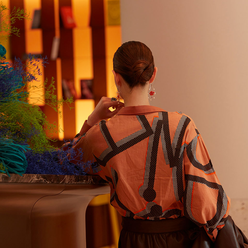 A woman leaning on a high table in hotel lobby