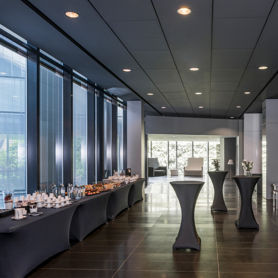 A large foyer with four large tables stacked with a wide variety of food and beverage refreshments