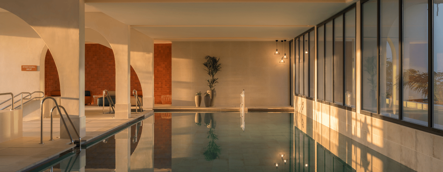 Indoor pool featuring a large window and a spacious wall, creating a bright and open atmosphere.