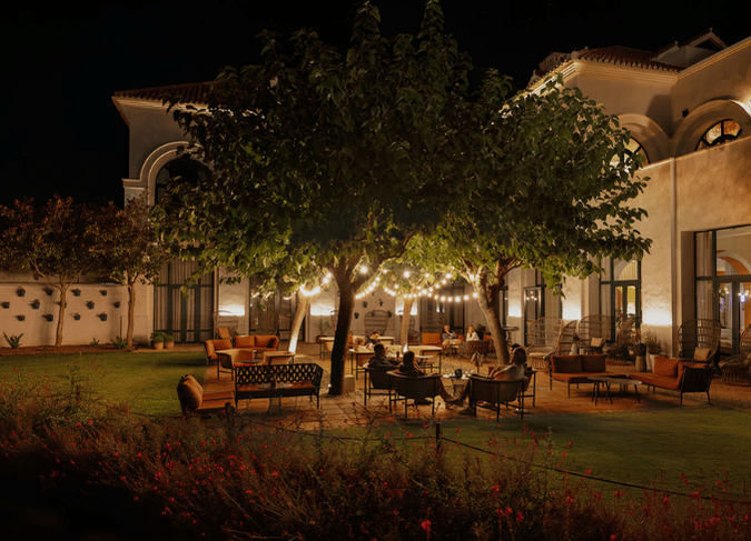 http://A%20nighttime%20patio%20scene%20illuminated%20by%20soft%20lights,%20showcasing%20outdoor%20furniture%20and%20a%20cozy%20atmosphere.