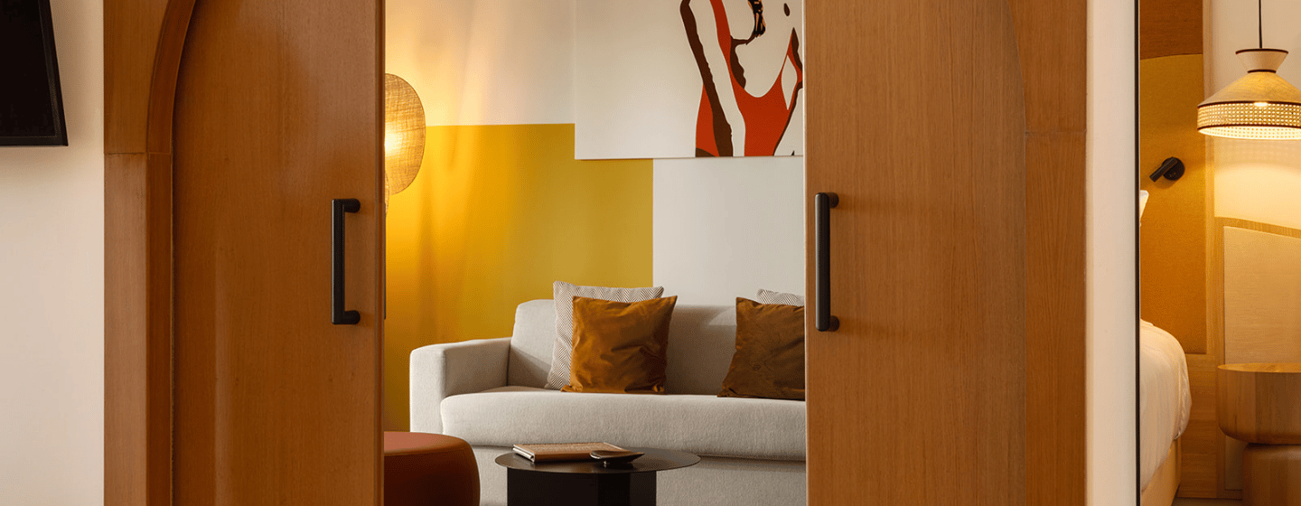 A cozy living room featuring a comfortable couch and a television mounted on the wall.