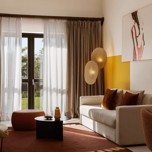 http://A%20cozy%20living%20room%20featuring%20a%20couch,%20coffee%20table,%20chair,%20lamp,%20and%20a%20window%20allowing%20natural%20light.