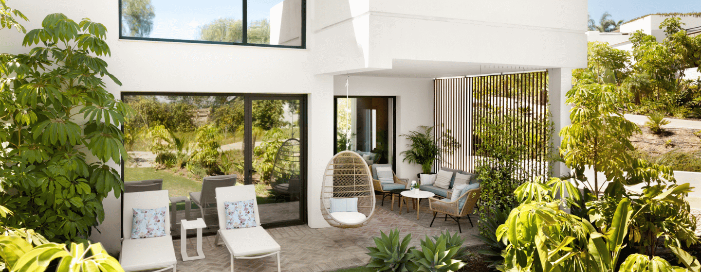 A contemporary home featuring a spacious patio and a well-maintained garden, showcasing greenery and outdoor living space.