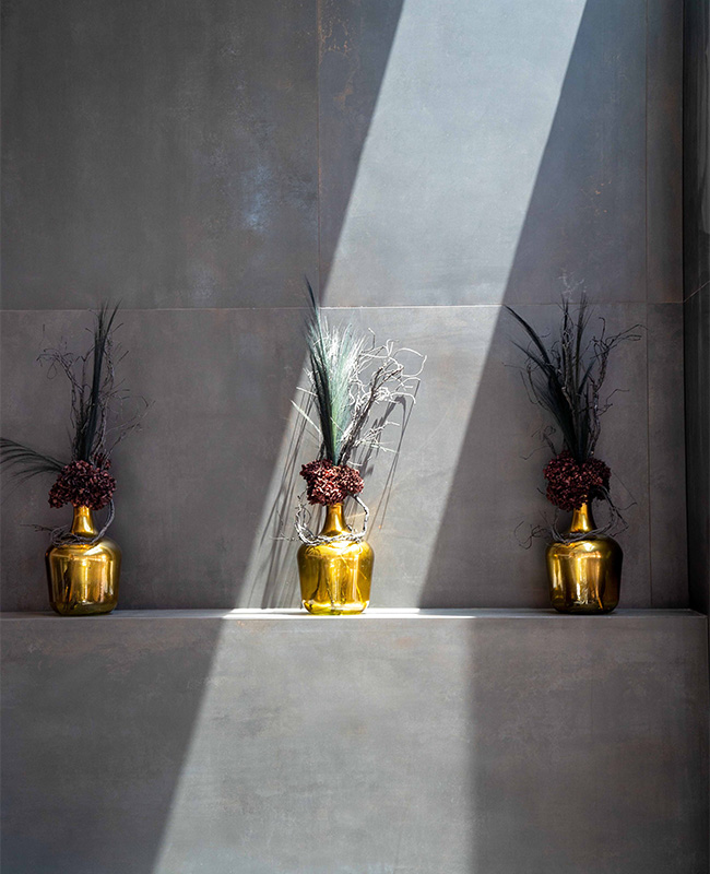 3 gold vases placed on a wall intergrated breakfast bar with a beam of natural light shining down