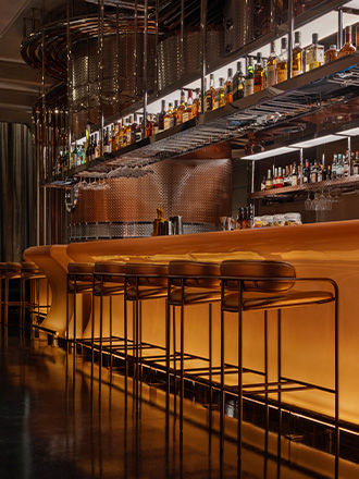 Golden illuminated bar counter with bar stools