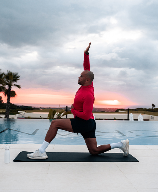 http://A%20man%20stretching%20on%20a%20yoga%20mat%20next%20to%20a%20pool