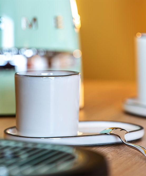 A whute ceramic mug and matching saucer