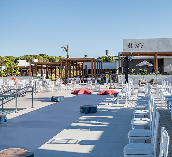 A large seating area beside a pool. In the background a building with 'Hi-SO/' on the wall