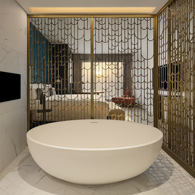 Freestanding bathtub in the vip suite with slatted gold partition visible behind.