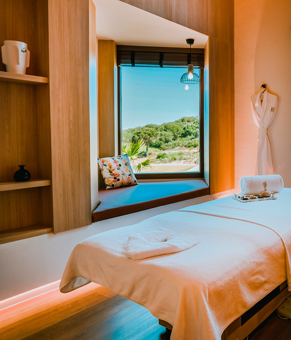 White-sheeted massage table in warm room with view across the coast