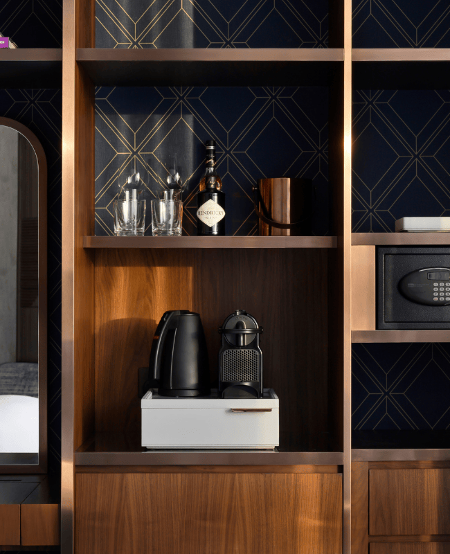 Detail image of hotel room amenities with minibar, coffee and tea station and safe