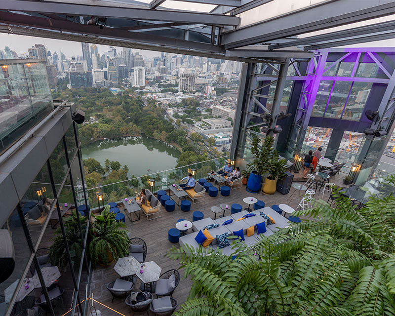 http://A%20birds%20eye%20view%20of%20a%20large%20rooftop%20seating%20area%20overlooking%20Bangkok%20including%20a%20park%20with%20a%20large%20pond%20in%20the%20middle