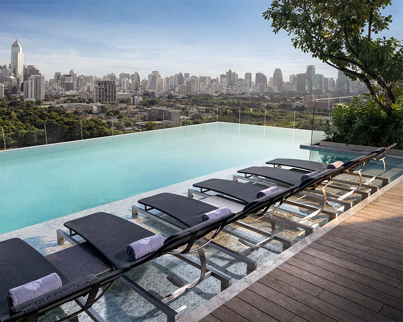 http://An%20infinity%20pool%20lined%20with%20sun%20loungers%20looks%20over%20the%20Bangkok%20skyline.