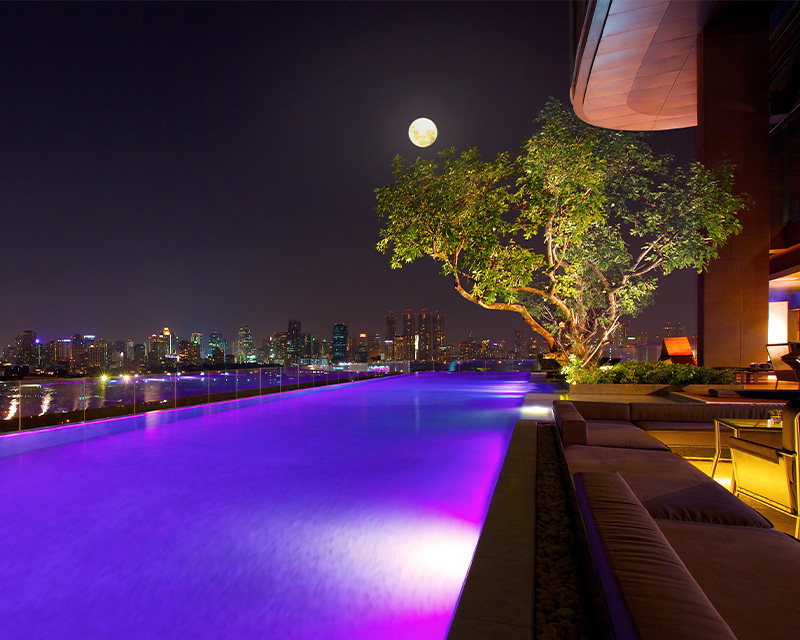 http://An%20inifinity%20lit%20up%20by%20purple%20lights%20looks%20over%20the%20Bangkok%20skyline%20at%20night.