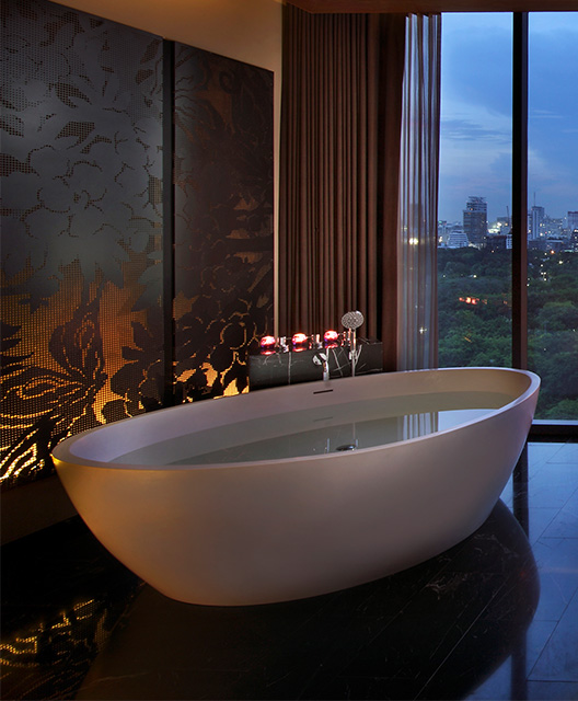 http://A%20large,%20full%20bathtub%20sits%20by%20a%20floor%20to%20ceiling%20window.