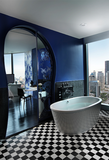 http://A%20bathroom%20with%20blue%20and%20black%20walls%20and%20chequered%20floor.%20A%20bathtub%20sits%20next%20to%20floor%20to%20ceiling%20window%20and%20an%20archway%20leads%20into%20a%20bedroom.