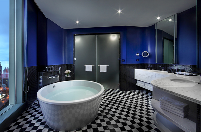 http://A%20bathroom%20with%20black%20and%20blue%20walls%20and%20chequered%20floor.%20A%20marbled%20double%20vanity%20sink,%20large%20mirror%20and%20circular%20bathtub.