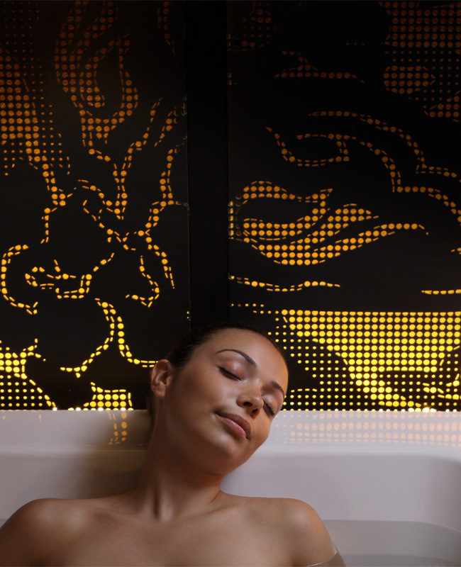 A woman relaxes in a bathtub.