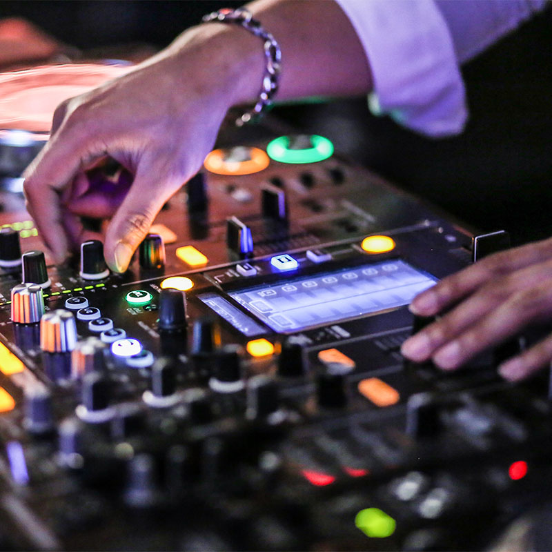 A hand turns a nob on a DJ deck.