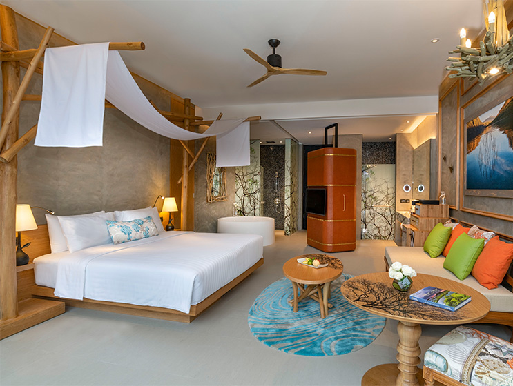 A cozy hotel room with a canopy bed, elegant wooden decor, and a small table with flowers. Warm lighting and minimalist design create a serene atmosphere.