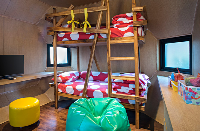 http://A%20cozy%20children's%20room%20with%20wooden%20bunk%20beds,%20red%20polka%20dot%20bedding,%20and%20a%20playful%20vibe.%20A%20green%20bean%20bag,%20yellow%20ottoman,%20and%20colorful%20storage%20bins%20add%20vibrancy.