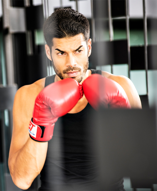 A man in a fighting stance wearing boxing gloves
