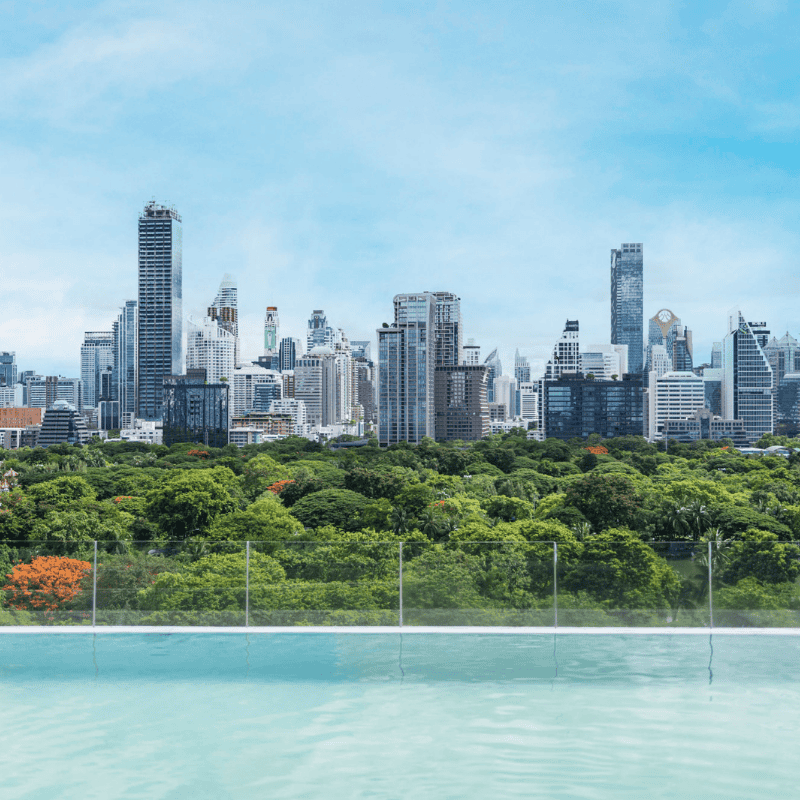 Infinity Pool at SO/ Bangkok overlooking Lumphini Park and the Bangkok skyline, with a serene, glass-edge perspective blending water and city views.