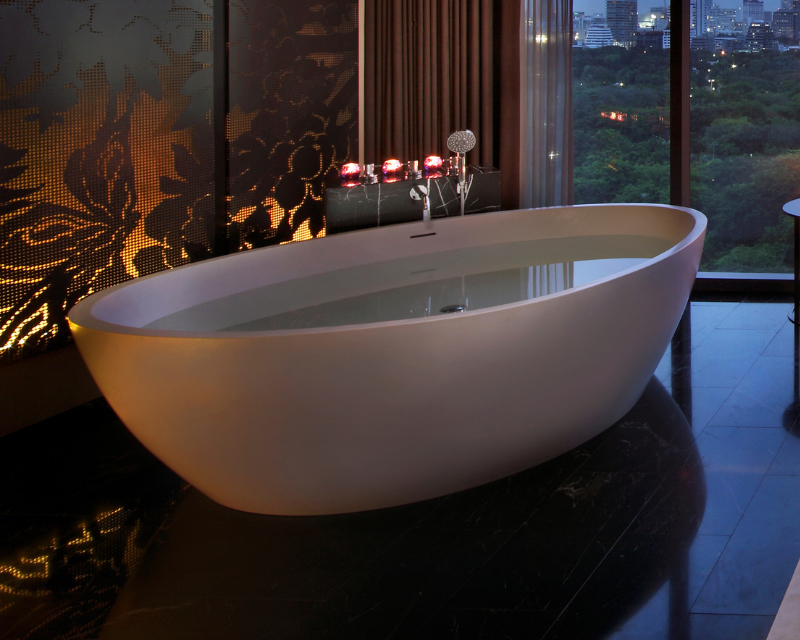 http://A%20sleek%20freestanding%20bathtub%20filled%20with%20water%20under%20soft%20candlelight,%20positioned%20next%20to%20a%20large%20glass%20window%20showing%20a%20city%20skyline%20and%20park%20at%20night.