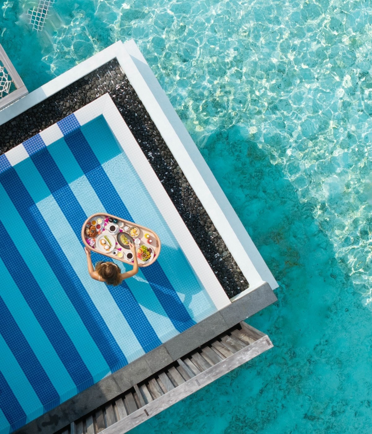 Pool surrounded by the sea with a floating breakfast tray.