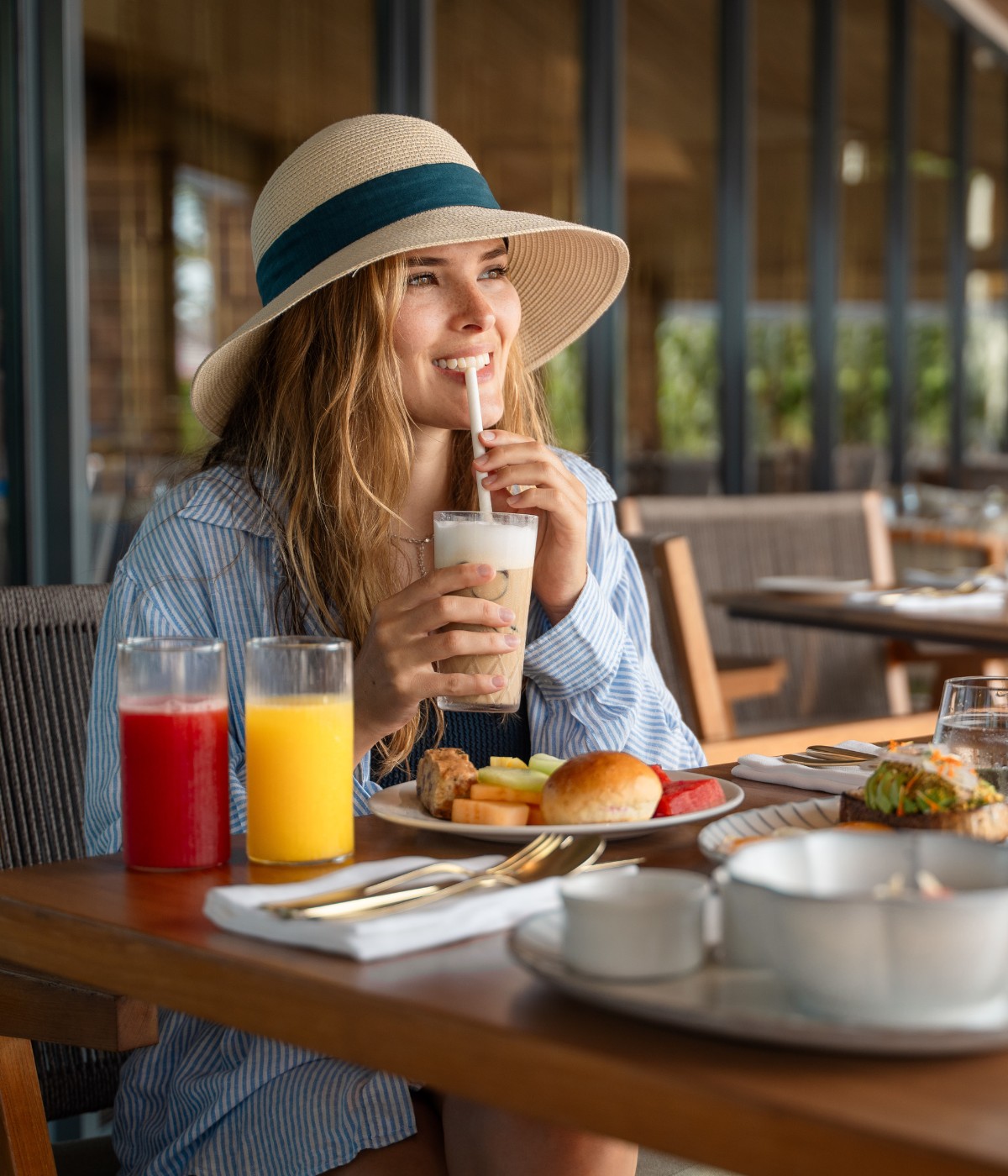 Woman on a table with fresh juices and breakfast on it.
