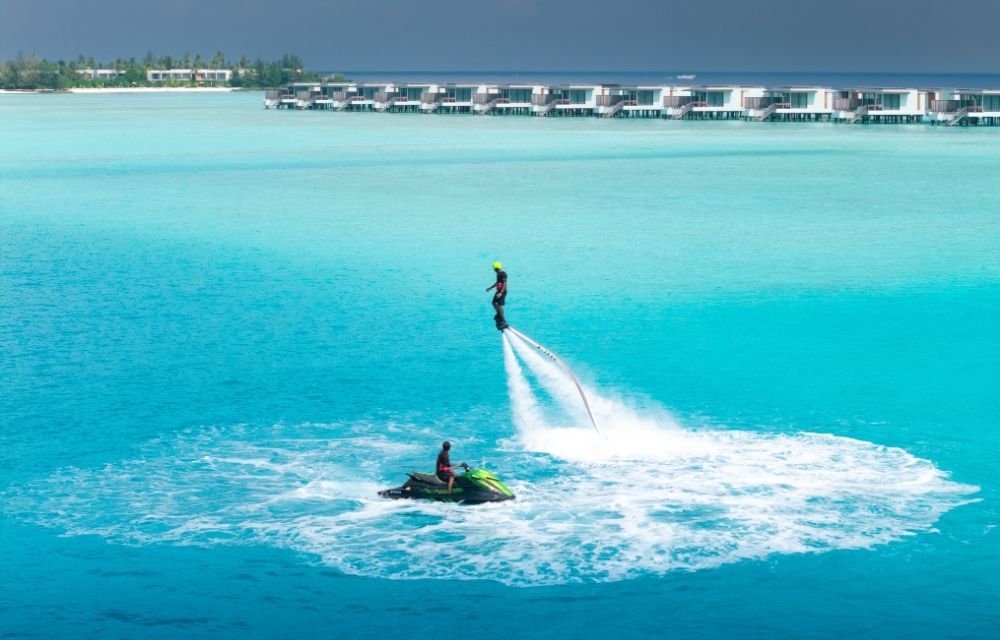 http://One%20person%20enjoying%20a%20jet%20ski%20ride%20in%20the%20open%20ocean%20under%20clear%20skies.%20And%20another%20one%20is%20doing%20underfeed%20hydro%20sports.