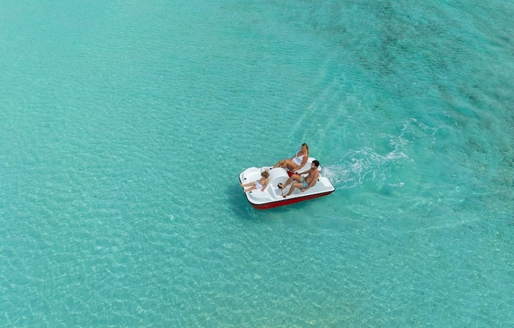 http://A%20family%20enjoying%20a%20ride%20on%20a%20pedal%20boat%20through%20the%20ocean,%20surrounded%20by%20clear%20blue%20water%20on%20a%20sunny%20day.