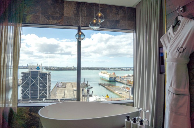 http://Spa-like%20bathroom%20with%20a%20freestanding%20tub,%20overlooking%20a%20harbor%20view%20through%20large%20windows,%20featuring%20soft%20curtains%20and%20elegant%20decor.