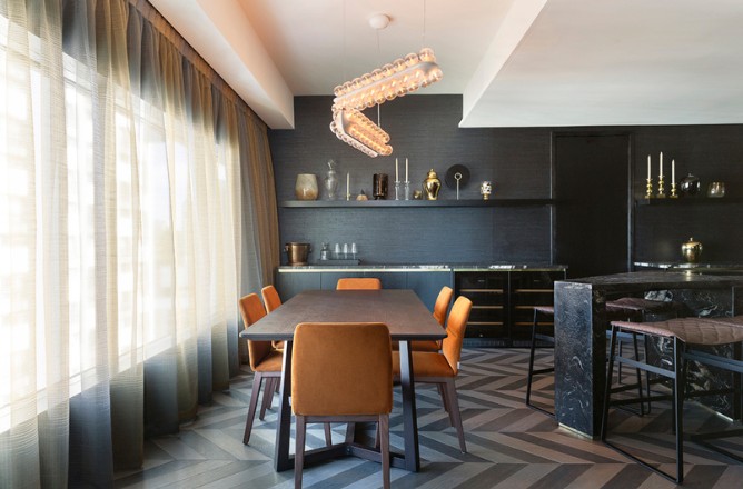 http://Modern%20dining%20area%20featuring%20a%20sleek%20table,%20orange%20chairs,%20elegant%20lighting,%20and%20dark%20decor%20with%20a%20herringbone%20floor%20pattern.