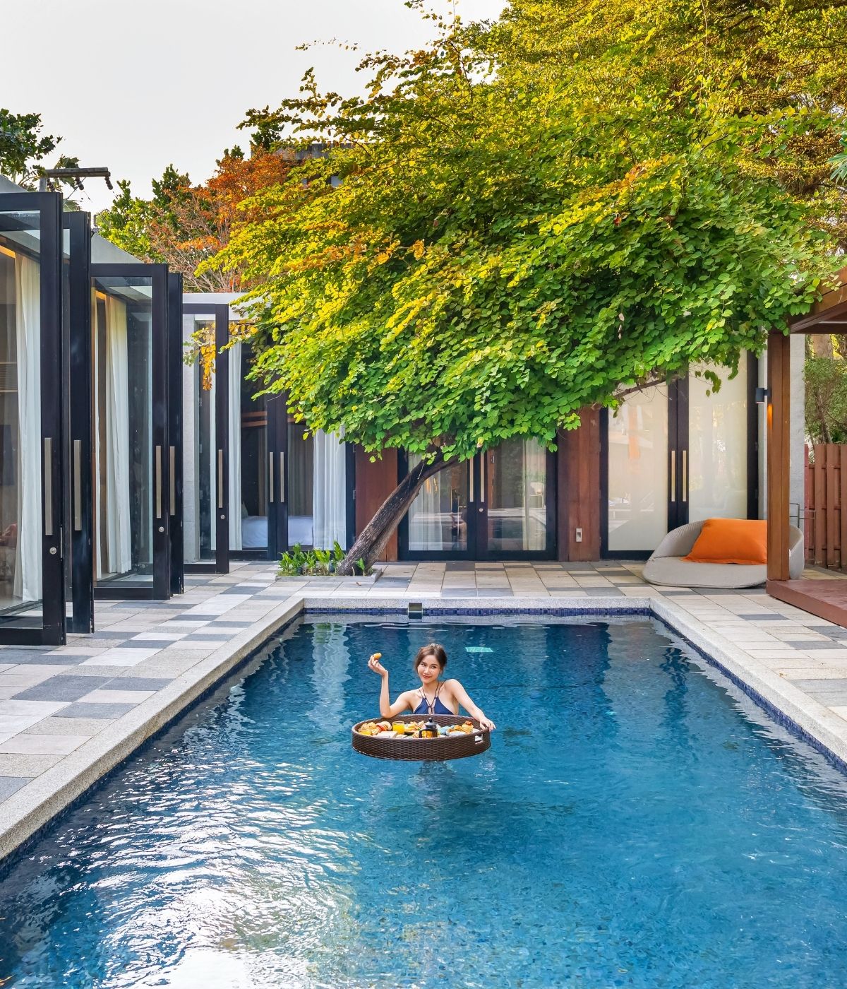 private pool villa featuring a guest enjoying a floating breakfast experience in a serene courtyard setting at SO/ Sofitel Hua Hin.
