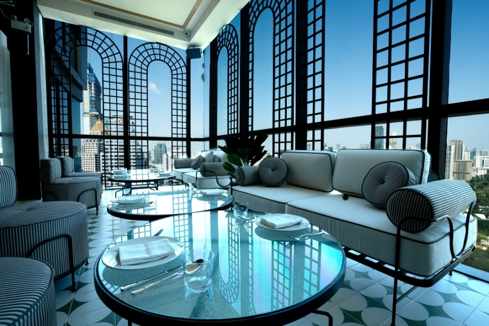 http://Luxurious%20rooftop%20lounge%20with%20arched%20windows,%20city%20view,%20blue%20sky.%20Elegant%20seating,%20glass%20tables,%20and%20comfortable%20cushions%20create%20a%20stylish,%20serene%20ambiance.