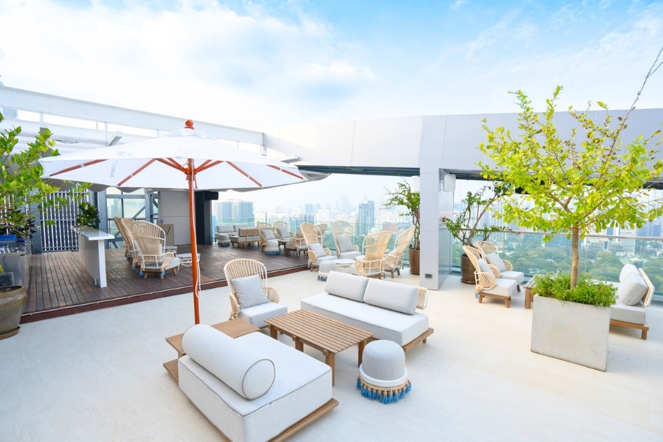 http://Rooftop%20terrace%20with%20chic%20white%20and%20beige%20seating,%20a%20large%20umbrella,%20and%20lush%20plants.%20Offers%20city%20skyline%20views%20under%20a%20clear,%20sunny%20sky.