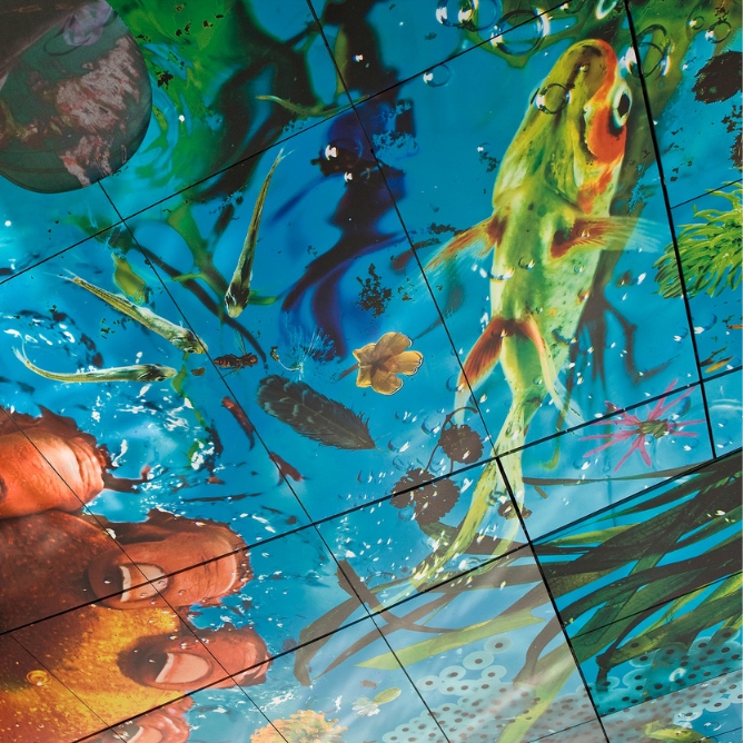 Ceiling art depicting an underwater scene with a large fish, plants, bubbles, and various aquatic life in vibrant colors, conveying a lively atmosphere.