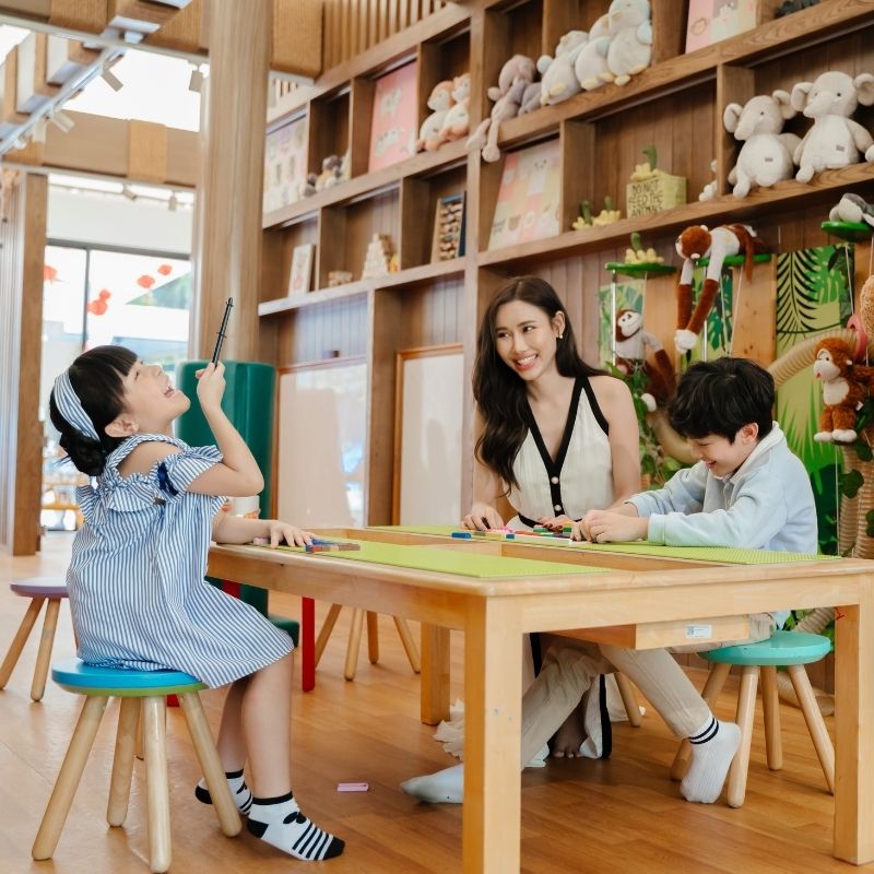 Smiling family enjoying indoor activities and playing with toys at the Kids Tent playroom at SO/ Sofitel Hua Hin