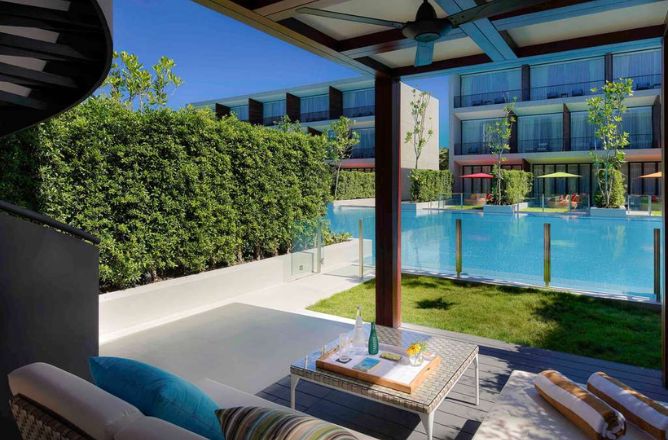 http://A%20spacious%20outdoor%20terrace%20with%20a%20comfortable%20daybed%20lounge%20area,%20a%20small%20table%20with%20refreshments,%20and%20a%20view%20of%20a%20private%20swimming%20pool,%20surrounded%20by%20lush%20green%20hedges.